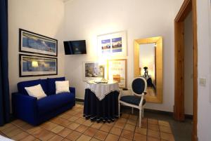 a room with a blue couch and a table and a mirror at Hotel Locanda Cairoli in Rome