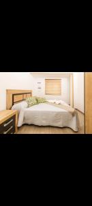 a bedroom with a large bed with a wooden headboard at Alojamiento el halcon in Santoña