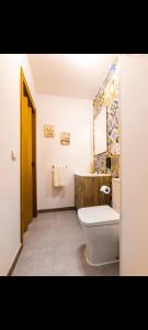 a bathroom with a toilet and a sink and a mirror at Alojamiento el halcon in Santoña