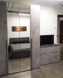 specchio in camera con letto e televisore di La Corte Charm Apartment- Where the memories are made a Genova