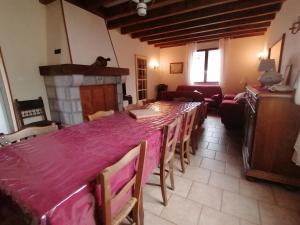 a room with a long table with chairs and a fireplace at Gîte Monplaisir in Gère-Belesten
