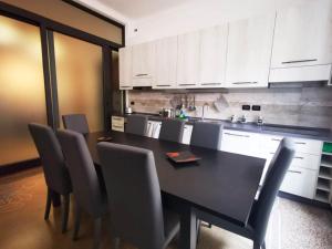 una cucina con tavolo e sedie neri di La Corte Charm Apartment- Where the memories are made a Genova Altre 15 foto