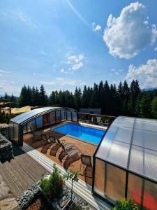 a glass house with a swimming pool on a deck at Chalupa Katka in Dolný Kubín