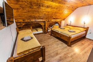 a bedroom with two beds in a wooden cabin at Chalupa Katka in Dolný Kubín +19 photos