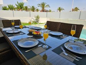 a table with glasses of wine and a bowl of fruit at Holiday Home KyDo - Heated Pool - Roof Terrace - San Pedro del Pinatar in San Pedro del Pinatar