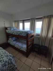 a bedroom with two bunk beds and a window at Stella Maris 55 in Amanzimtoti