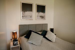 sypialnia z łóżkiem z trzema zdjęciami na ścianie w obiekcie Apartament Domek Romi w Augustowie do wynajęcia w mieście Augustów