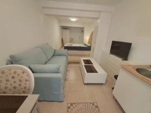 a living room with a blue couch and a sink at Apartamento MOTA 8 in Xeraco