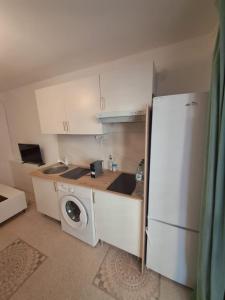a kitchen with a white refrigerator and a washing machine at Apartamento MOTA 8 in Xeraco