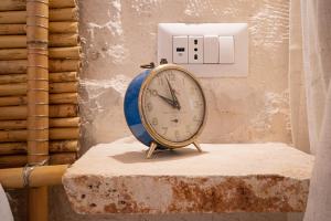 a clock sitting on a table next to a lightswitch at Arcueve Casa Vacanze in Ceglie Messapica