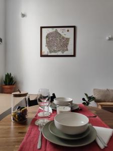 a dining room table with a red table runner with plates and glasses at Casa Pátio do Megué in Évora +21 photos