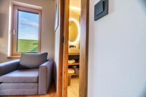 a living room with a chair and a window at Hotel Frost in Maribor