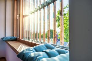 a blue couch sitting in front of a large window at Hotel Frost in Maribor