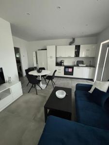 ein Wohnzimmer mit einem blauen Sofa und einem Tisch in der Unterkunft Apartman Tanja & Apartman Tea in Galižana