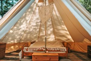 MiłkiMiła Łąka Glamping的帐篷内的一张床位,配有天篷