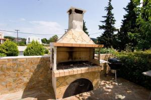 einen Steinkamin im Hof mit Grill in der Unterkunft Iliovasilema in Edipsos