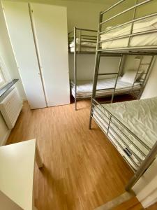 a room with two bunk beds and a wooden floor at Hällestrand Vandrarhem - Lägenhet "Laxen" in Strömstad +21 photos