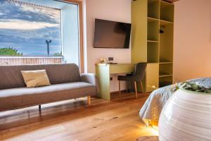 a living room with a couch and a desk at Hotel Frost in Maribor
