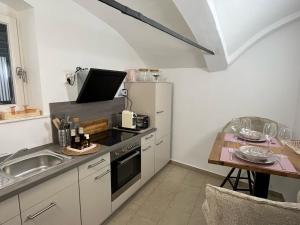 a small kitchen with a sink and a table at Die Französin - Ingo Telschow & Catherine Tempier Gbr in Deidesheim