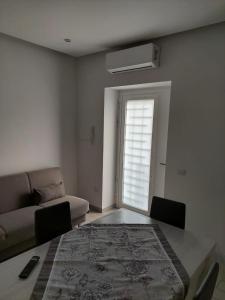 a living room with a table and a couch at Gaia Pia Home in Bacoli