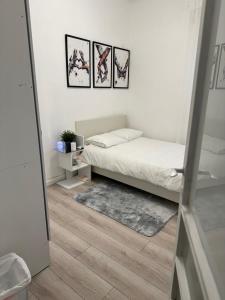 a bedroom with a bed and three pictures on the wall at 3 rooms apartment on the beach in Tel Aviv