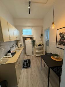 a kitchen with white cabinets and a table in it at 3 rooms apartment on the beach in Tel Aviv