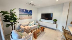 un soggiorno con un divano e una TV di Wariruri Condo Aruba a Palm Beach