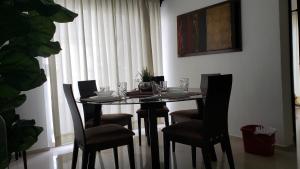 a dining room table with chairs and a table with glasses at Departamento equipado a unos pasos de la playa, 2 Recamaras Aire acondicionado in Manzanillo