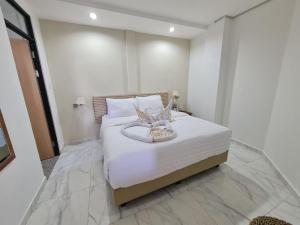 a bedroom with a large bed with white sheets at La bianca Home in Kota
