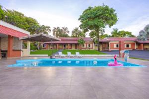 une piscine avec un jouet rose devant une maison dans l'établissement Rancho Colonial 6 suítes acesso ao Lago das Brisas, à Corumbazul