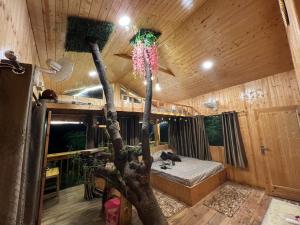a room with a tree with a bed in it at Chamba Valley Glamping in Chamba