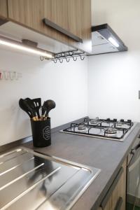 Una encimera de cocina con una estufa y una taza de utensilios. en B&B Casa dell'Ingegnere, en Carosino