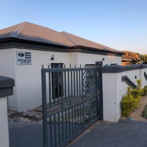 a white house with a gate in front of it at Buffalo guest lodge in Bushbuckridge