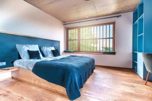 a bedroom with a large bed with a blue blanket at Hotel Frost in Maribor