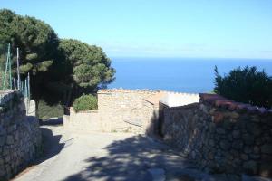 a stone wall with trees and the ocean in the background at Elba stunning sea view private peaceful property in La Guardia