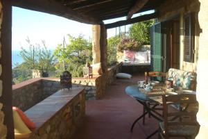 a patio with a table and chairs on a stone wall at Elba stunning sea view private peaceful property in La Guardia