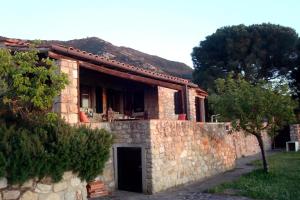 a stone house with a stone wall at Elba stunning sea view private peaceful property in La Guardia +7 photos