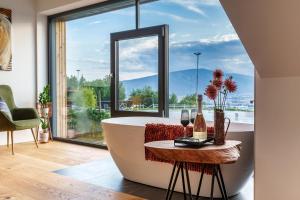 a bath tub in a room with a large window at Hotel Frost in Maribor