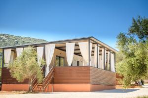 una casa con tende bianche sul davanti di Luxury and Cosy Little House Ivinj 2 a Tisno (Stretto)