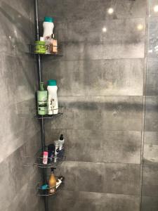 une salle de bain avec quatre étagères avec des produits de nettoyage au mur dans l'établissement Rooms near the Beach Cabanyal and Universities, à Valence 5 autres photos