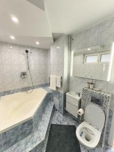 a bathroom with a tub and a toilet and a sink at 20 Apartment Centre in Bucharest +7 photos