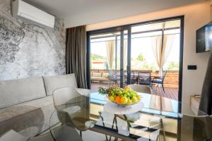 un soggiorno con tavolo in vetro e cesto di frutta di Luxury and Cosy Little House Ivinj 3 a Tisno (Stretto)
