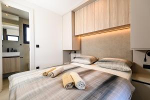 una camera da letto con un letto grande con asciugamani sopra di Luxury and Cosy Little House Ivinj 3 a Tisno (Stretto) Altre 46 foto
