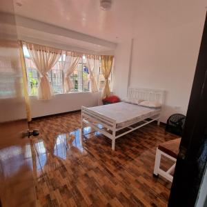 a bedroom with a bed and a large window at Bahay Ko spacious house in Sariaya Quezon in Sariaya