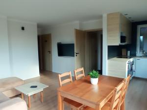 a kitchen and dining room with a wooden table and chairs at Domek agroturystyczny in Zawada