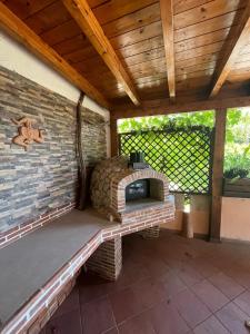a patio with a brick oven with a wooden roof at Villa Casablanca in SantʼAlessio Siculo