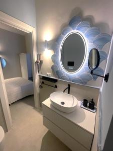 a bathroom with a sink and a mirror on the wall at Kyria Luxury Apartment in Vulcano +28 photos