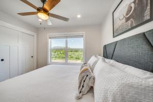 una camera da letto con un letto e un ventilatore a soffitto di Private Hot Tub Newly Built Fraser Townhome a Fraser