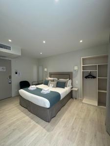 a bedroom with a large bed in a room at Kyriad Saumur Hyper Centre Hôtel Appartements et SPA soins Sothys Paris in Saumur