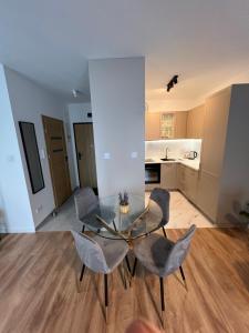 a dining room with a glass table and chairs at Mikołowska Small Heaven - free underground parking in Katowice